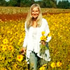Kelly standing in her field of sunflowers